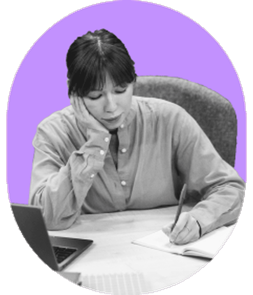 Female student studying late at desk with notebook and laptop popping out of wide orchid rose arch